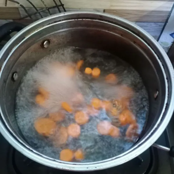 Didihkan air di panci, masukkan wortel. Masak sampai wortel setengah matang.
