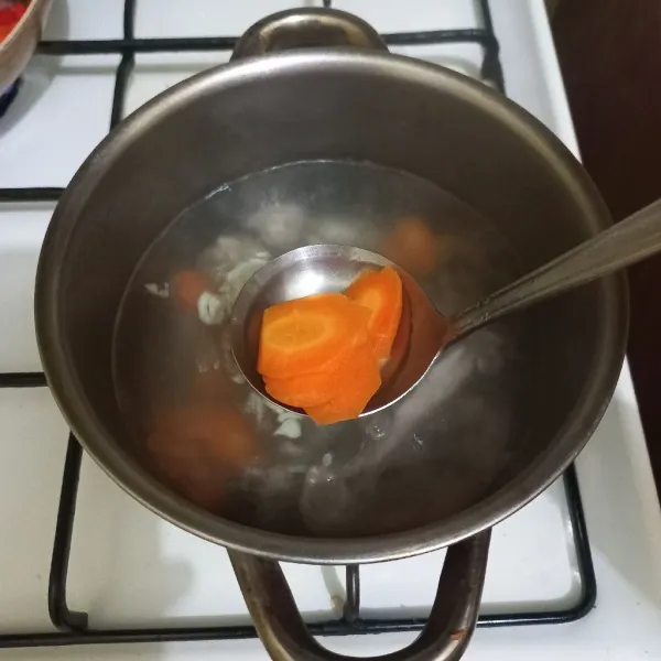 Masukkan irisan wortel dan bawang putih cincang.