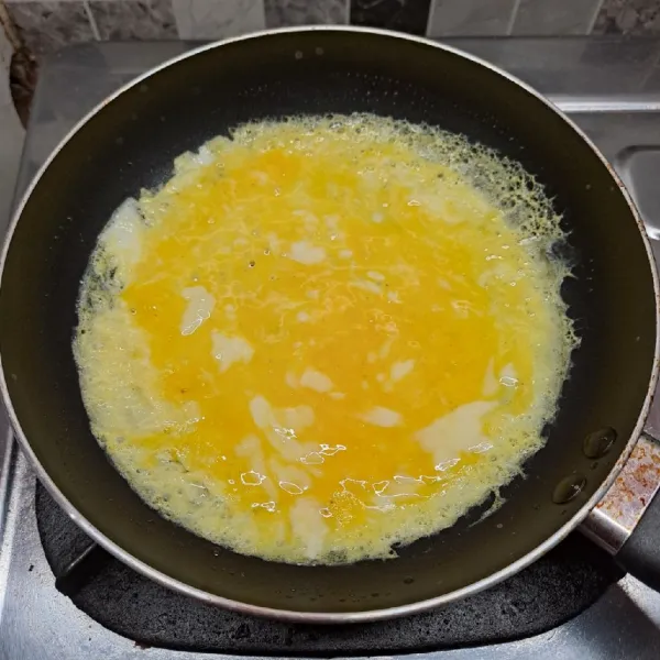 Kocok telur, merica bubuk dan kaldu jamur sampai rata. Panaskan teflon dengan api kecil dan sedikit minyak goreng. Tuang adonan telur.