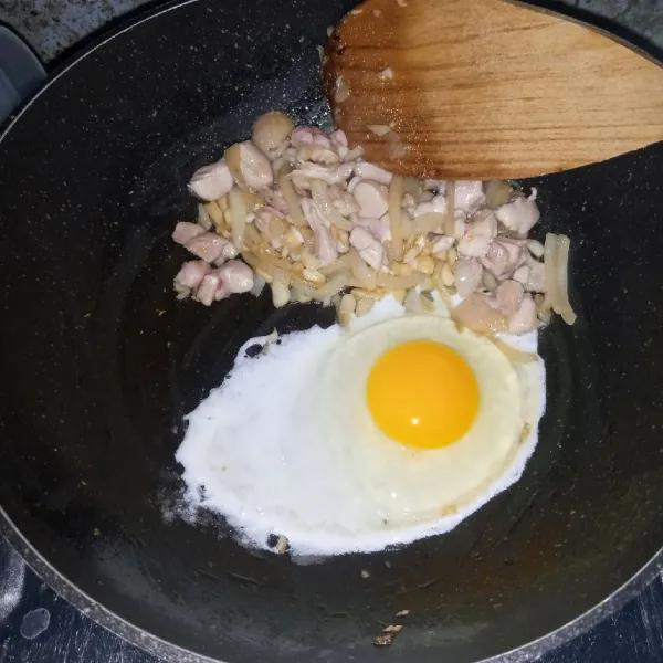 Masukkan ayam. Masak sampai berubah warna. Kemudian tambahkan telur ayam. Masak sambil diorak-arik.
