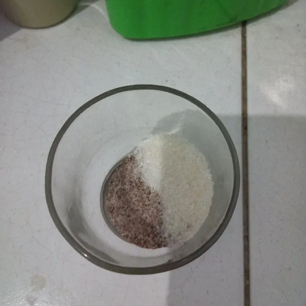 Tuang kopi bubuk dan gula pasir ke dalam gelas.