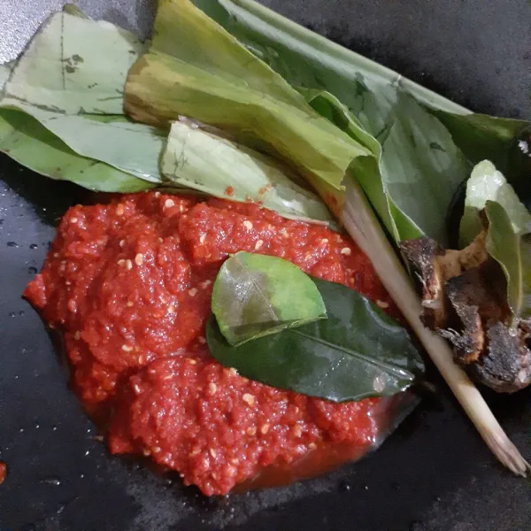 Pada wajan, letakkan bumbu halus, daun kunyit, serai, daun jeruk purut.