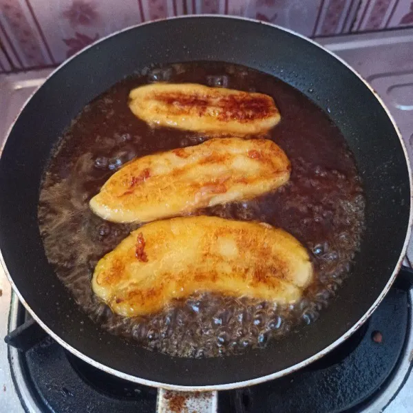 Tuang kuah gula merah ke dalam teflon yang berisi pisang panggang.