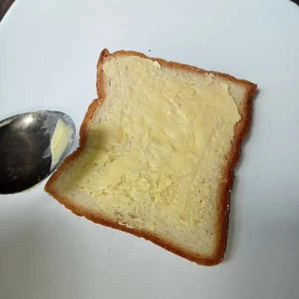 Olesi roti dengan margarin.