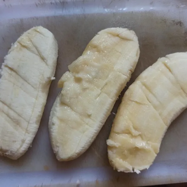 Kupas pisang kemudian pipihkan.