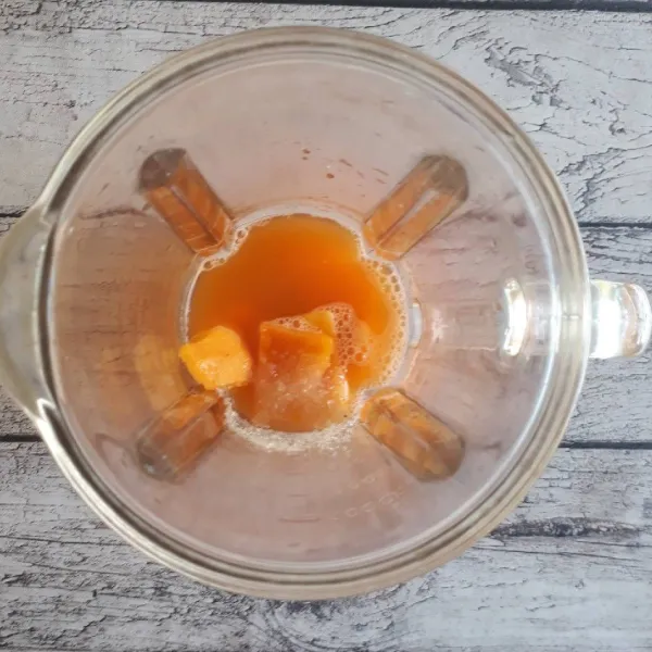Masukkan jus wortel yang sudah disaring, mangga dan gula pasir ke dalam blender.