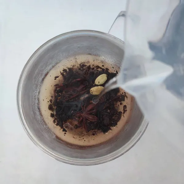 Tuang air panas ke dalam gelas, biarkan sampai warna teh keluar dan air menjadi hangat.