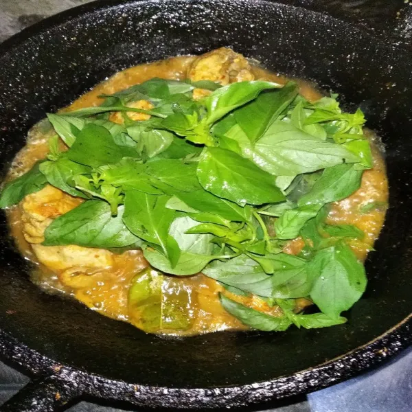 Bila ayam sudah empuk, masukkan daun kemangi, beri gula, garam dan kaldu bubuk.