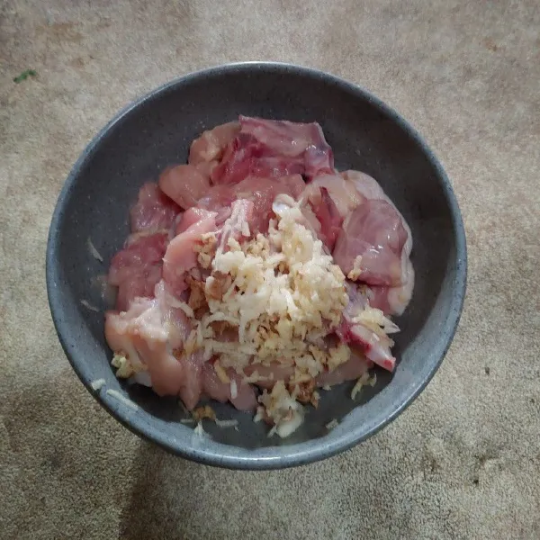 Potong daging ayam kecil kecil, tambahkan bawang putih parut dan jahe parut.