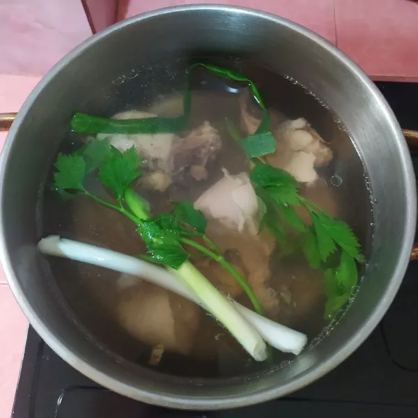Rebus ayam dan buang air rebusannya yang pertama. Kemudian rebus dengan air sisa merebus sayuran. Masukkan seledri dan daun pre. Kalau ayam sudah empuk, lalu keluarkan dan potong dadu.