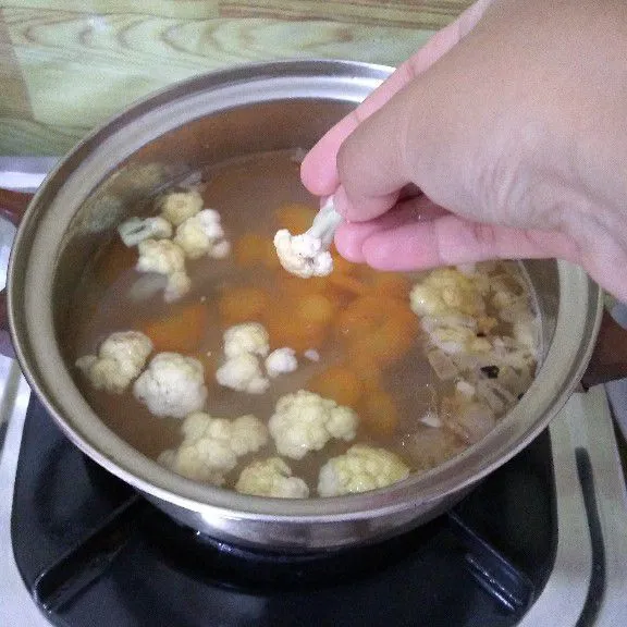 Masukkan wortel masak hingga setengah empuk lalu tambahkan kembang kol.