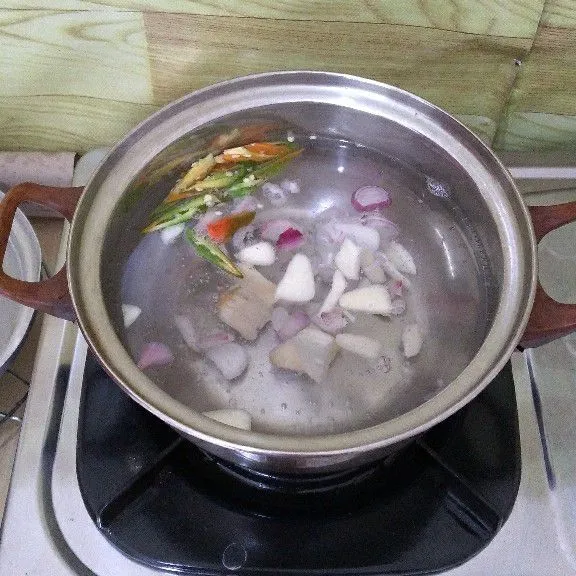 Rebus air hingga mendidih lalu masukkan bawang merah, bawang putih, cabe rawit, lengkuas geprek masak hingga aromanya harum.