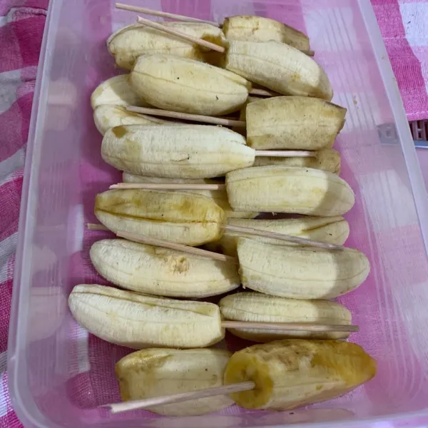 Tusuk-tusuk pisang dengan tusukan sate lalu simpan pisang didalam freezer semalam atau hingga pisang beku.