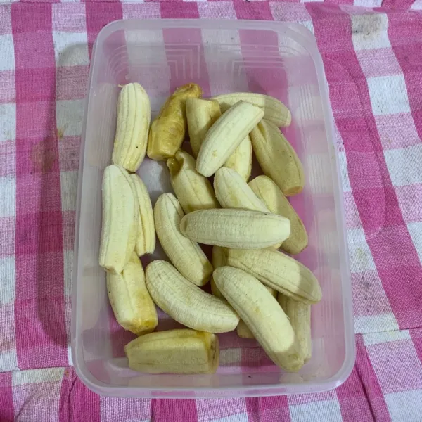 Kupas kulit buah pisang, sisihkan pisangnya.