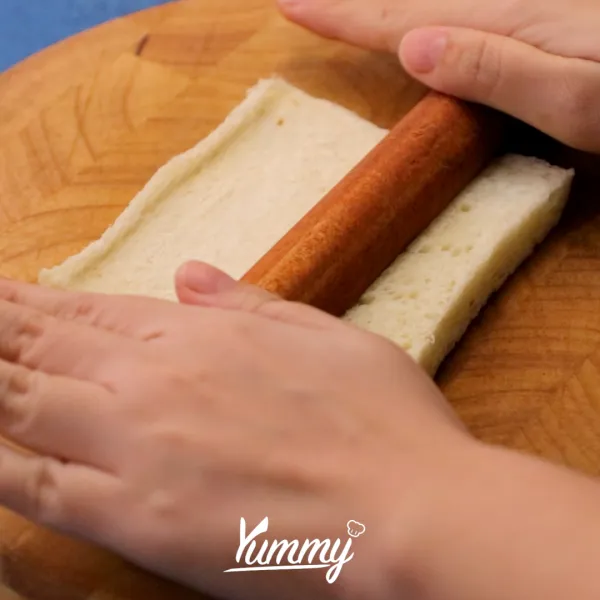 Pipihkan roti tawar. Potong bagian atas, bawah, kanan, dan kiri roti tanpa putus. Kemudian letakkan di loyang.
