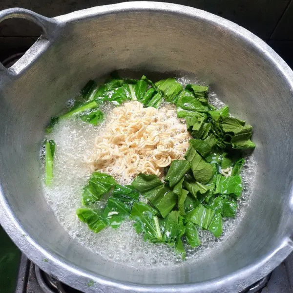 Masak mie bersama dengan sayur sawit hijau, masak sampai mie matang.
