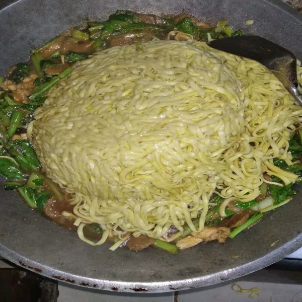 Masukkan mie, aduk rata, beri minyak wijen, aduk lagi hingga rata, koreksi rasa dan sajikan.