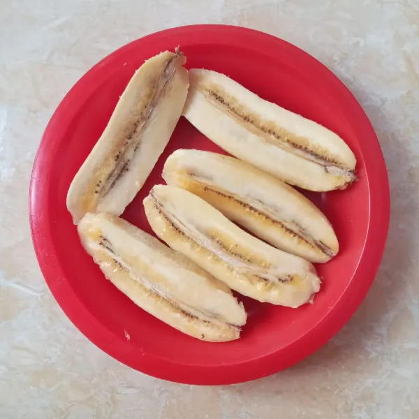 Belah memanjang pisang menjadi 2 bagian.