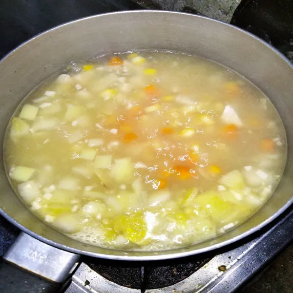 Masukkan  wortel dan jagung, tambahkan air, beri garam dan kaldu bubuk.
