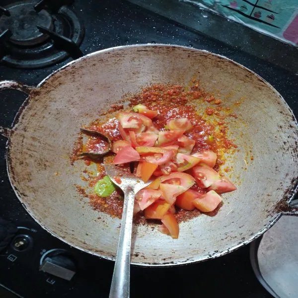 Kemudian masukkan irisan tomat, agak pencet-pencet dengan sutil agar tomat hancur, bumbui dengan gula, garam, penyedap rasa.