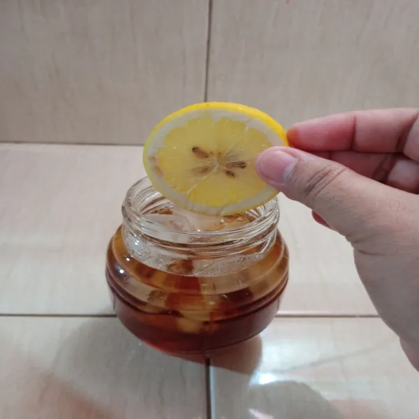 Tuang air teh yang sudah dingin, kemudian masukkan irisan lemon, sajikan.