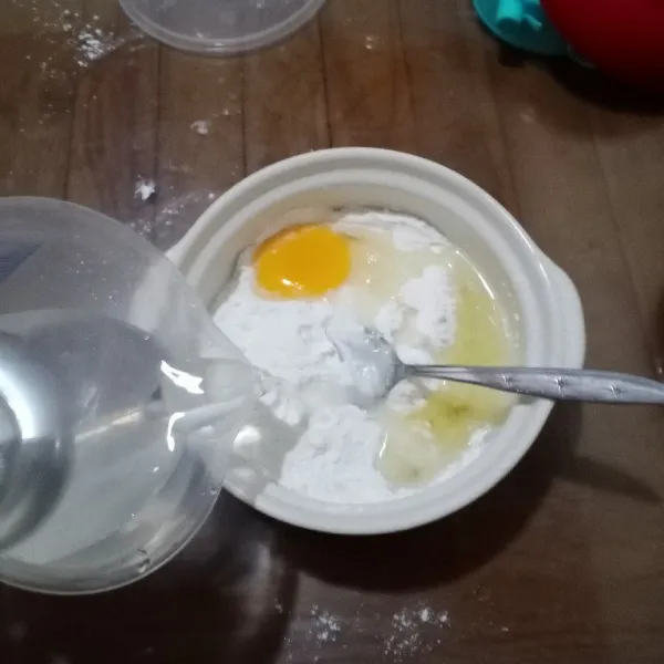 Campur semua bahan kering, aduk rata. Masukkan telur, tuang air sedikit demi sedikit.