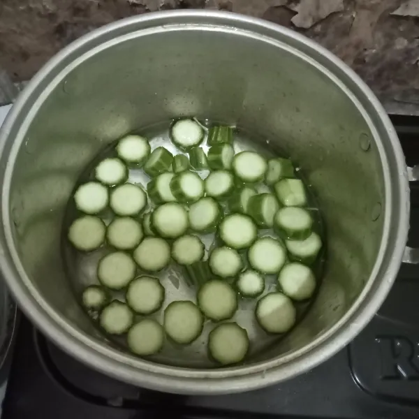 Masukkan bawang putih dan oyong pada panci yang sudah diisi air.