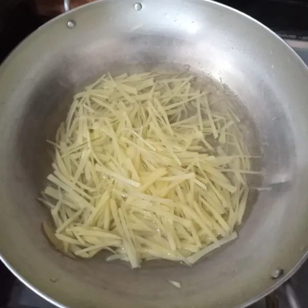 Kupas kentang lalu iris memanjang dan halus, cuci lalu peras, kemudian beri sedikit garam.