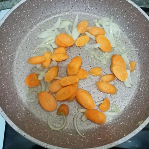 Tambahkan air dan masukkan wortel. Masak hingga wortel setengah matang.