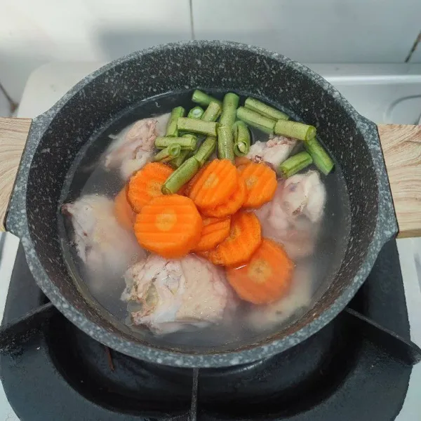 Setelah ayam empuk, masukkan wortel dan buncis. Rebus hingga empuk.