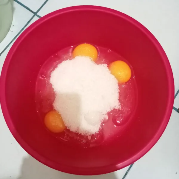 Kocok telur dengan gula hingga putih dan mengembang.