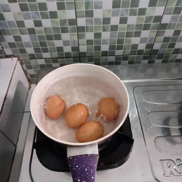 Rebus telur hingga matang, kemudian dinginkan dan kupas.
