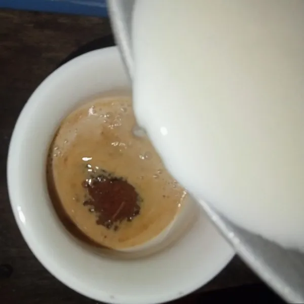 Tuang susu cengkeh kedalam gelas kopi.