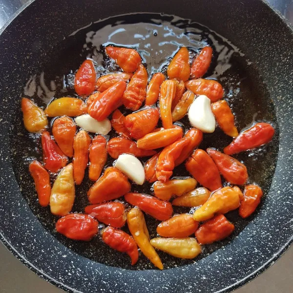 Sambal asin : Goreng cabai rawit merah dan bawang putih ke dalam minyak panas selama 1 menit. Angkat dan tiriskan.