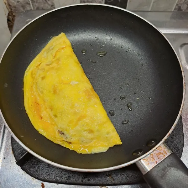 Lipat telur, kemudian tekan bagian tepinya agar menempel. Masak sampai matang. Angkat lalu potong 4 bagian. Sajikan di atas piring dengan topping saos tomat dan mayonnaise.