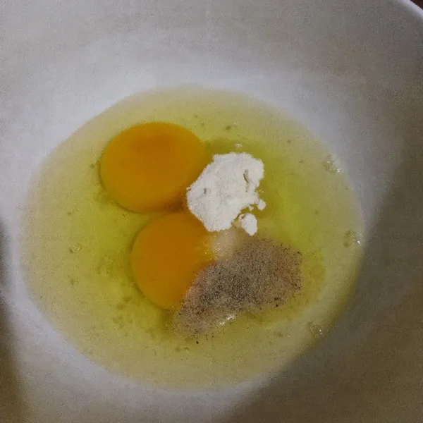 Dalam wadah pecahkan telur, beri bawang putih bubuk, lada, garam dan kaldu jamur. Kocok lepas.