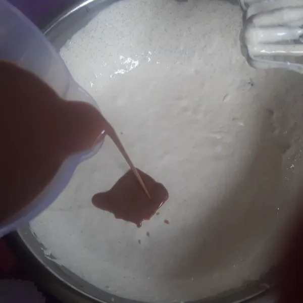Masukkan kental manis cokelat yang sudah dilarutkan terlebih dahulu dengan air. Kocok dengan whisk/ mixer.