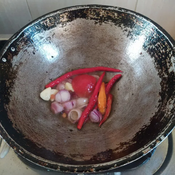 Panaskan minyak, goreng bawang merah, bawang putih, cabai merah keriting, cabai rawit merah dan tomat, hingga matang.