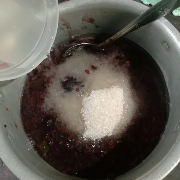 Pindahkan bubur ketan hitam ke panci yang lebih kecil, beri gula, garam, dan air sebanyak 300 ml. Aduk rata. Masak sampai gula larut dan bubur meletup-letup.