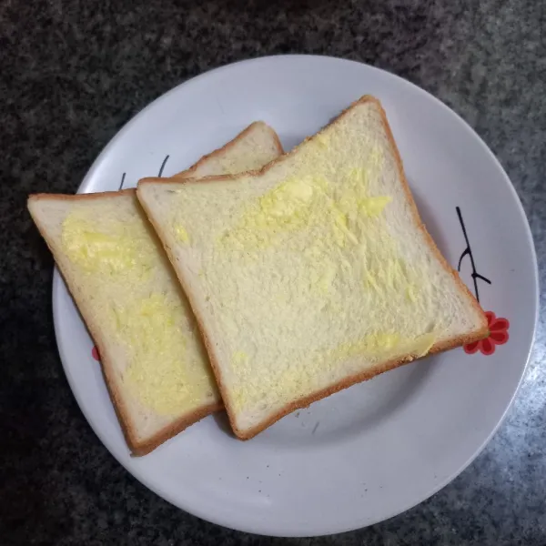 Olesi salah satu bagian roti dengan margarin, ratakan, potong roti menjadi masing-masing 4 bagian.