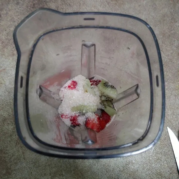 Masukan buah kiwi dan strawberry ke dalam blender, lalu tambahkan gula dan air.