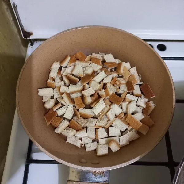 Panaskan telfon, masukkan potongan pinggiran roti, tambahkan minyak goreng.