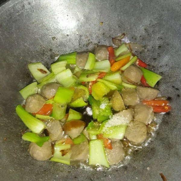 Tambahkan air, saus tiram, garam, kaldu bubuk dan gula pasir, aduk rata, masak hingga batang pokcoynya setengah matang.