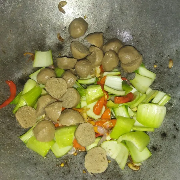 Masukkan batang pokcoy dan bakso, aduk rata.
