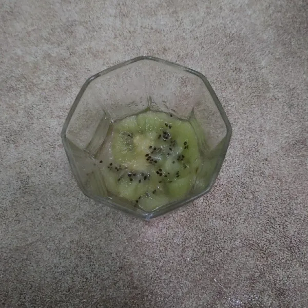 Siapkan gelas, masukkan buah kiwi dan sedikit dihancurkan menggunakan sendok.