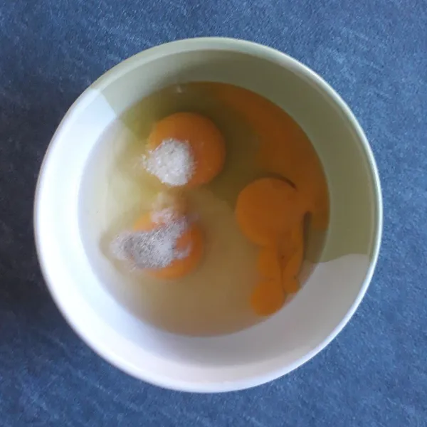 Masukkan telur, garam, kaldu bubuk dan merica bubuk ke dalam mangkuk lalu kocok lepas.
