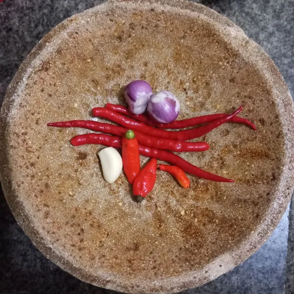 Haluskan bawang merah, bawang putih, cabe rawit dan cabe merah keriting.