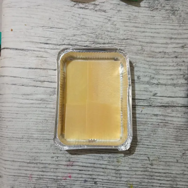 Siapkan loyang aluminium foil yang sudah dioles margarin, lalu letakkan pasta lasagna.