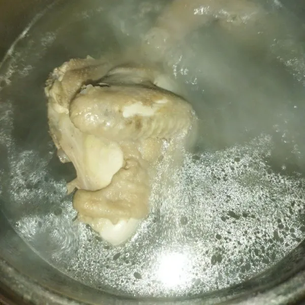 Masak air hingga mendidih, lalu rebus daging ayam hingga setengah matang.