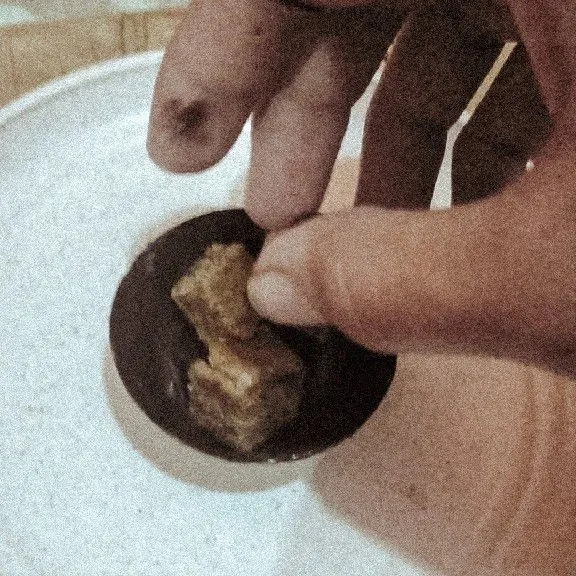 Oleskan sedikit cokelat cair diatas piring agar choco bomb nya kokoh, letakkan choco bomb, lalu masukkan kue bolu.